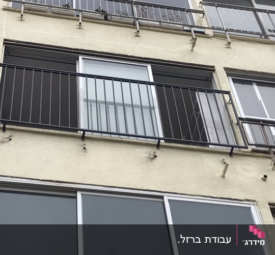 מעקה מתכת שחור על מרפסת בניין